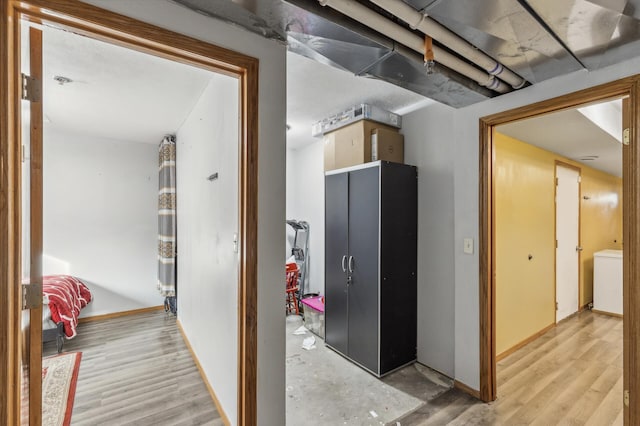 hallway featuring baseboards and light wood-style floors