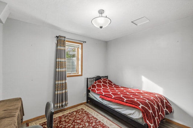 bedroom with baseboards and wood finished floors