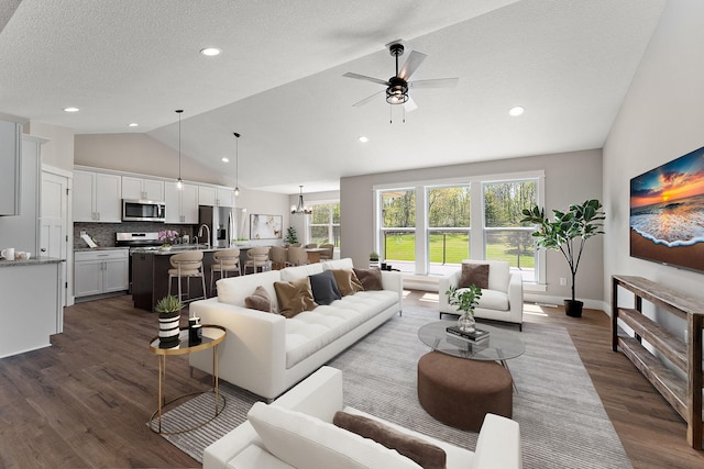 living room with lofted ceiling, dark wood finished floors, ceiling fan, a textured ceiling, and recessed lighting