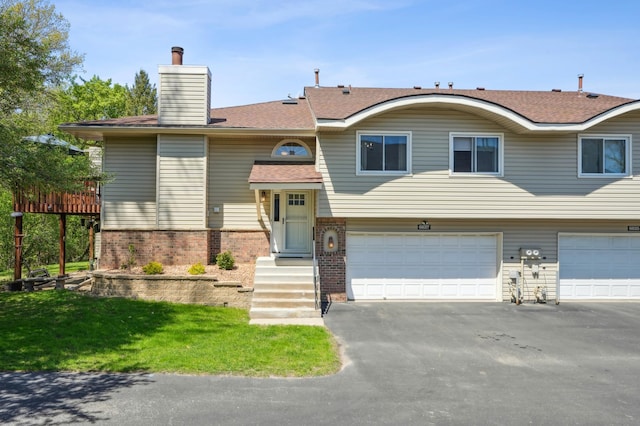 6637 Falstaff Rd, Woodbury, MN 55125 - split foyer home with a garage, asphalt driveway, brick siding, and a front lawn