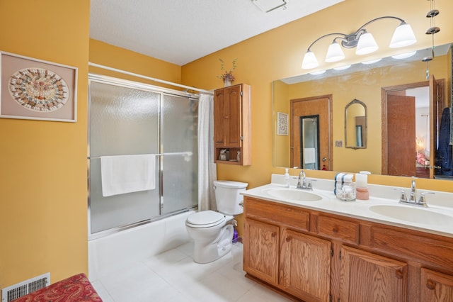 6637 Falstaff Rd, Woodbury, MN 55125 - bathroom with tile patterned floors, toilet, double vanity, and shower / bath combination with glass door