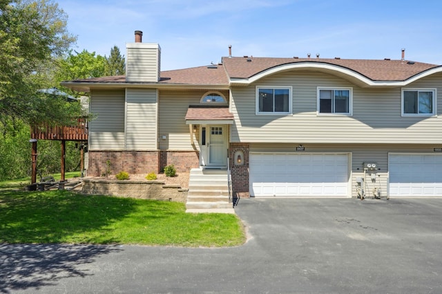 6637 Falstaff Rd, Woodbury, MN 55125 - view of front of house with brick siding, driveway, an attached garage, and a chimney