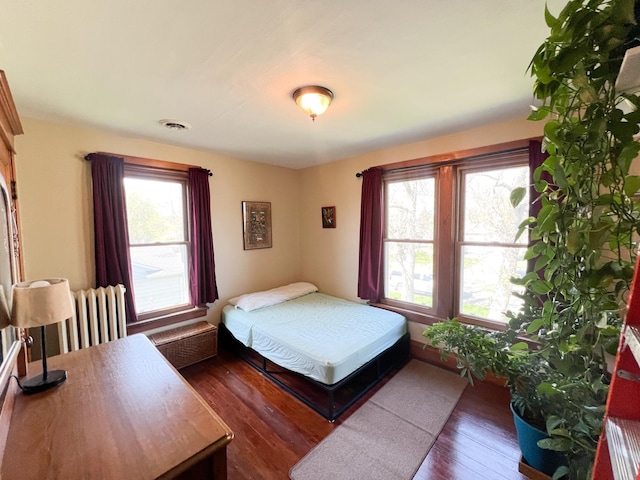 406 Pennsylvania Ave, Adrian, MN 56110 - bedroom featuring dark wood-style flooring, visible vents, and radiator heating unit
