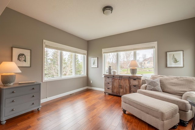 living area with baseboards and wood finished floors