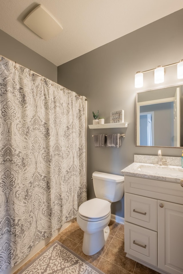 bathroom with toilet, tile patterned floors, vanity, and curtained shower