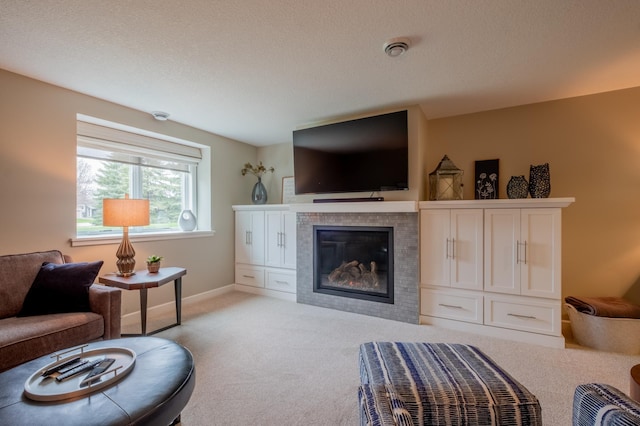 living area with light colored carpet, a tiled fireplace, and baseboards
