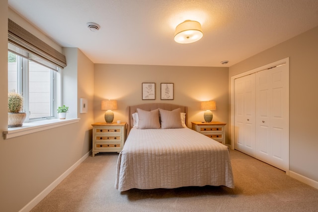 carpeted bedroom with baseboards and a closet