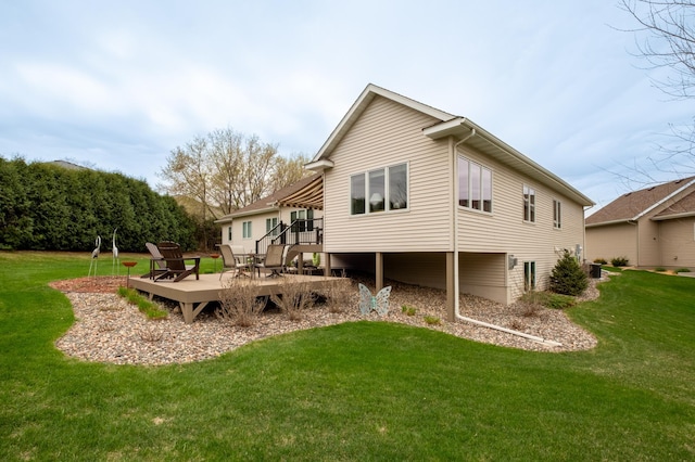 back of property with a lawn and a wooden deck