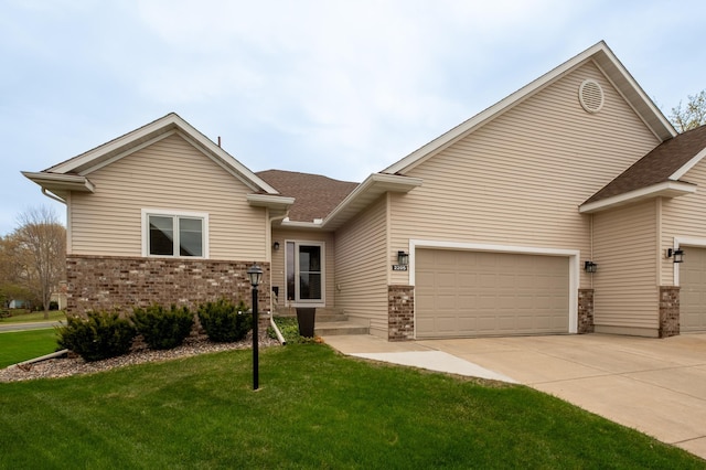 view of front of home with roof with shingles, concrete driveway, a front lawn, and brick siding