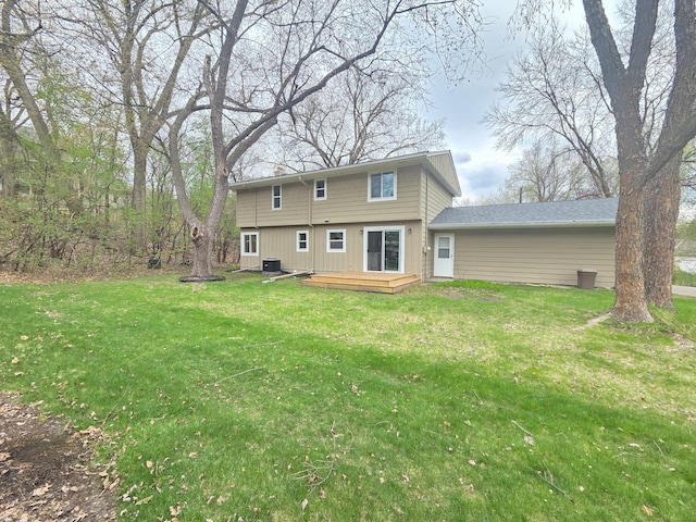 rear view of house featuring a lawn, central AC unit, and a deck