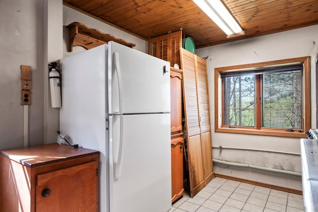 kitchen featuring freestanding refrigerator, wood ceiling, and light tile patterned floors