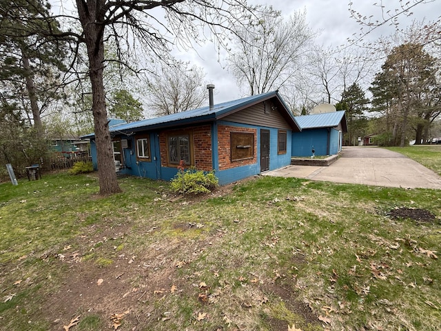exterior space featuring a yard, metal roof, and concrete block siding