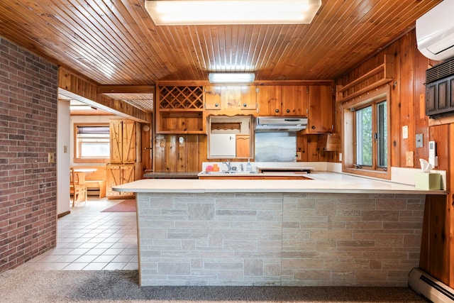 kitchen with light tile patterned floors, wood ceiling, baseboard heating, under cabinet range hood, and light countertops