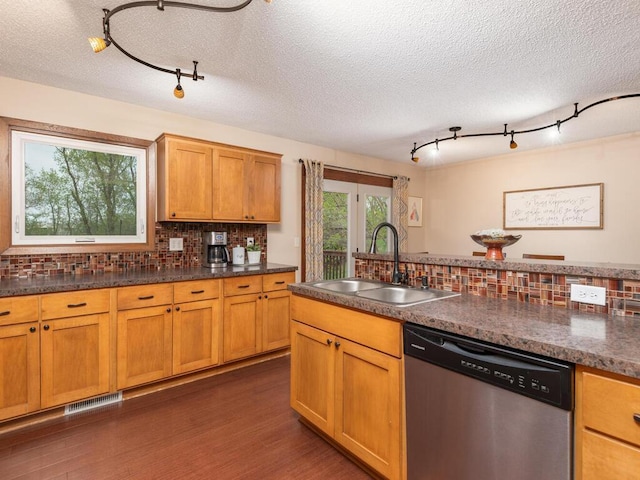 kitchen with track lighting, decorative backsplash, visible vents, a sink, and dishwasher