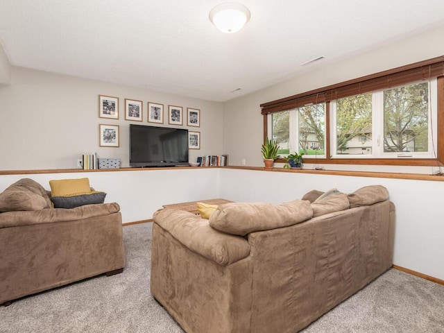 carpeted living area featuring baseboards