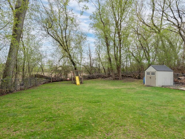 view of yard featuring a fenced backyard, an outbuilding, and a storage shed