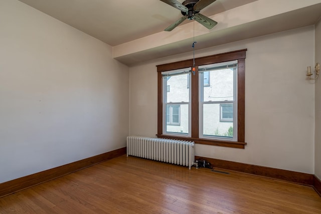 165 Park Ave, Le Center, MN 56057 - empty room featuring radiator heating unit, wood finished floors, and ceiling fan