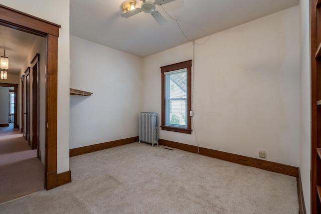 165 Park Ave, Le Center, MN 56057 - carpeted empty room with radiator heating unit and a ceiling fan