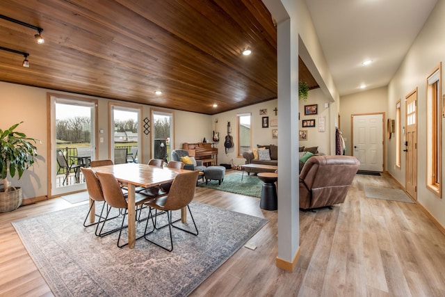 dining room with baseboards, wood ceiling, and light wood-style floors
