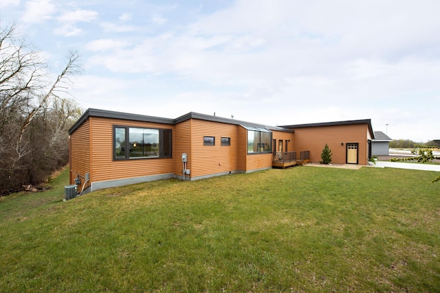 view of front of house with a deck, central AC, and a front lawn