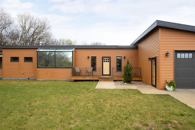 contemporary house featuring a garage, a deck, and a front yard