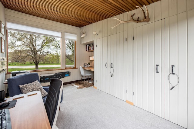 office area with wooden ceiling, carpet floors, and wood walls