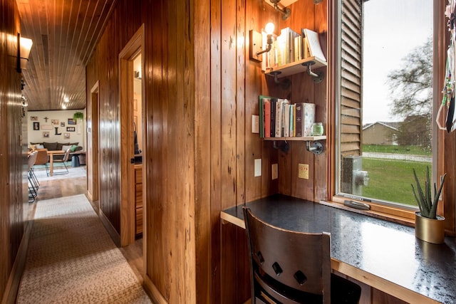 hallway featuring wood walls, wood finished floors, and wooden ceiling
