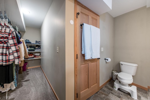 bathroom featuring baseboards and toilet
