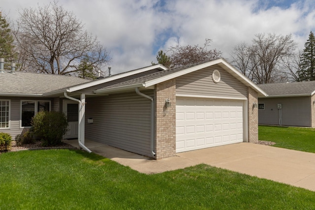 view of side of home featuring a lawn, brick siding, a shingled roof, an attached garage, and driveway