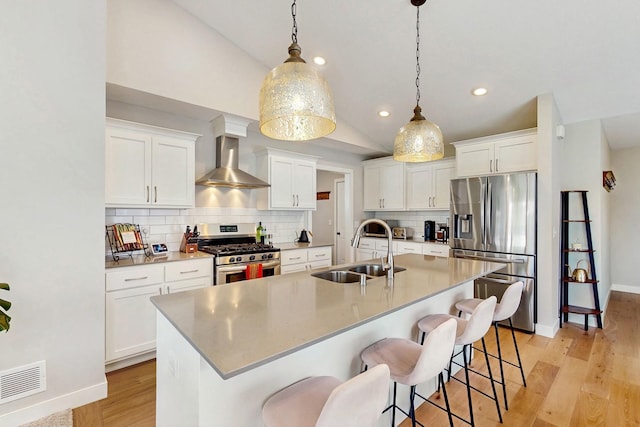 10725 Knollwood Ln, Woodbury, MN 55129 - kitchen featuring appliances with stainless steel finishes, a sink, wall chimney range hood, vaulted ceiling, and backsplash