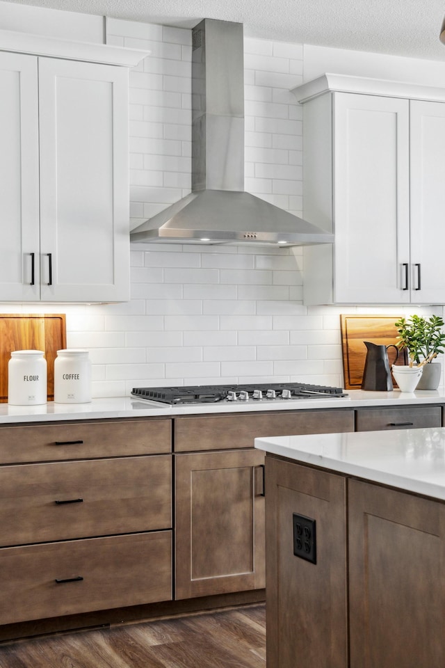14580 106th Pl N, Maple Grove, MN 55369 - kitchen featuring wall chimney range hood, backsplash, light countertops, dark wood-style floors, and white cabinetry