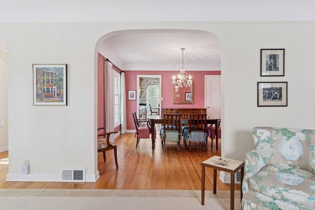 1870 Eleanor Ave, Saint Paul, MN 55116 - dining space with light wood-style flooring, arched walkways, and a chandelier