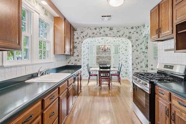 1870 Eleanor Ave, Saint Paul, MN 55116 - kitchen featuring gas stove, wallpapered walls, light wood finished floors, dark countertops, and brown cabinets