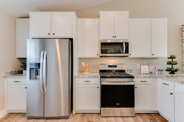 12018 71st St NE, Otsego, MN 55330 - kitchen with lofted ceiling, light stone countertops, light wood-style floors, white cabinets, and appliances with stainless steel finishes