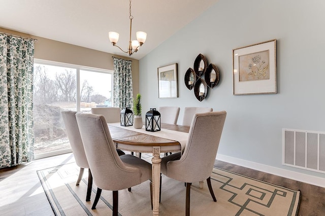 12018 71st St NE, Otsego, MN 55330 - dining space featuring visible vents, vaulted ceiling, wood finished floors, baseboards, and a chandelier