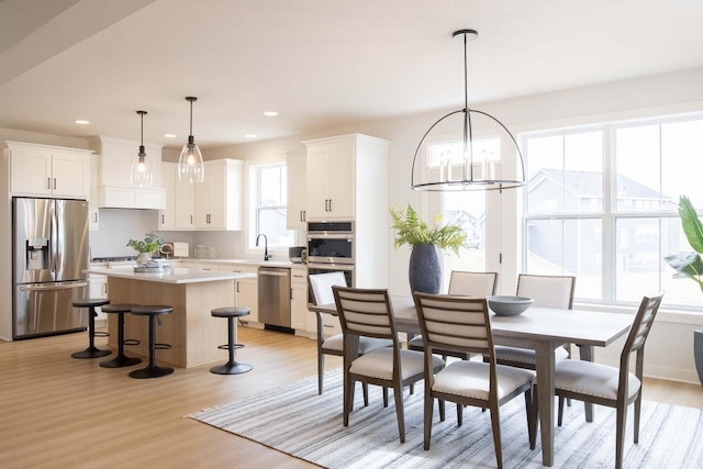 10451 Blackmoor Rd, Woodbury, MN 55129 - dining area featuring recessed lighting, a notable chandelier, and light wood-style flooring