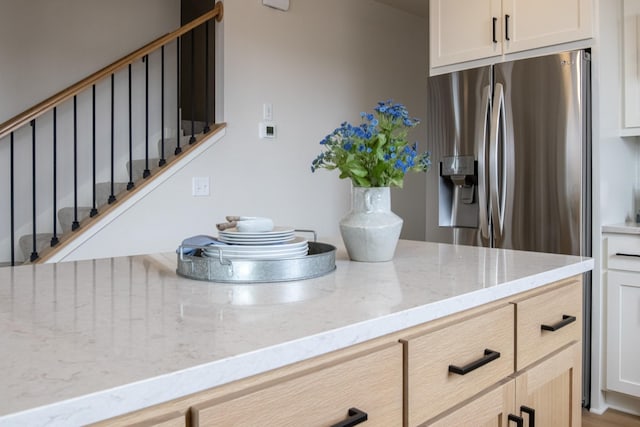 10451 Blackmoor Rd, Woodbury, MN 55129 - kitchen featuring light stone counters and stainless steel fridge with ice dispenser