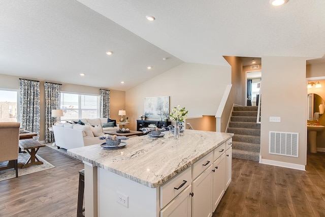 12301 71st Ct NE, Otsego, MN 55330 - kitchen featuring wood finished floors, a center island, white cabinetry, open floor plan, and light stone counters