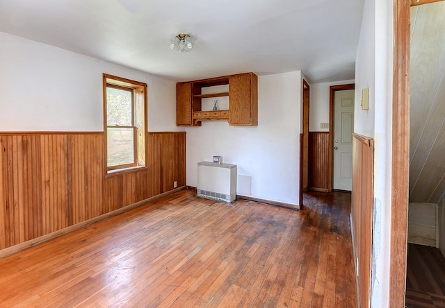 6575 145th St E, Cannon City Twp, MN 55057 - unfurnished room featuring hardwood / wood-style flooring, a wainscoted wall, and wooden walls
