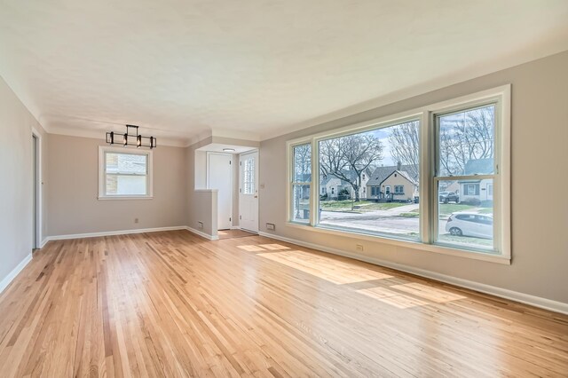 unfurnished living room featuring light wood-type flooring and baseboards
