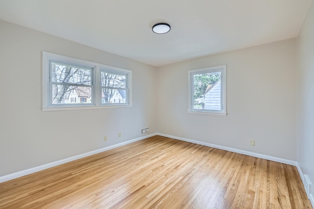 empty room featuring light wood-type flooring and baseboards
