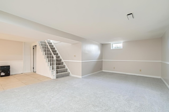 below grade area with carpet, stairway, and baseboards