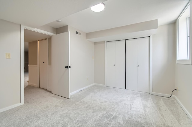 unfurnished bedroom with light carpet, baseboards, and a closet