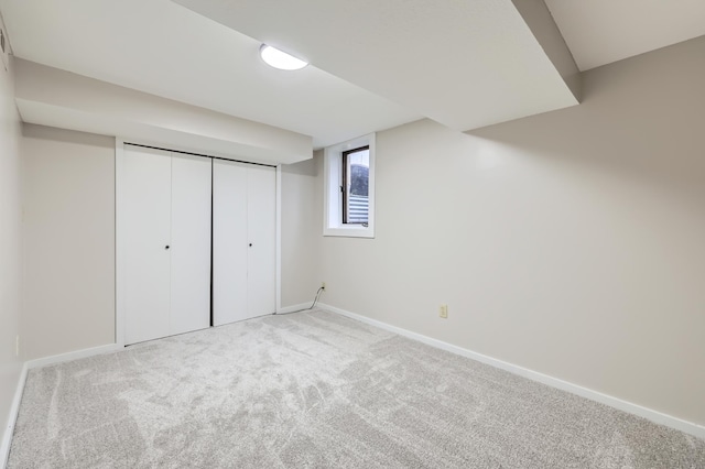 unfurnished bedroom featuring carpet floors, baseboards, and a closet
