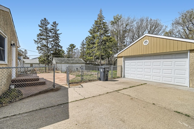 detached garage with a gate and fence