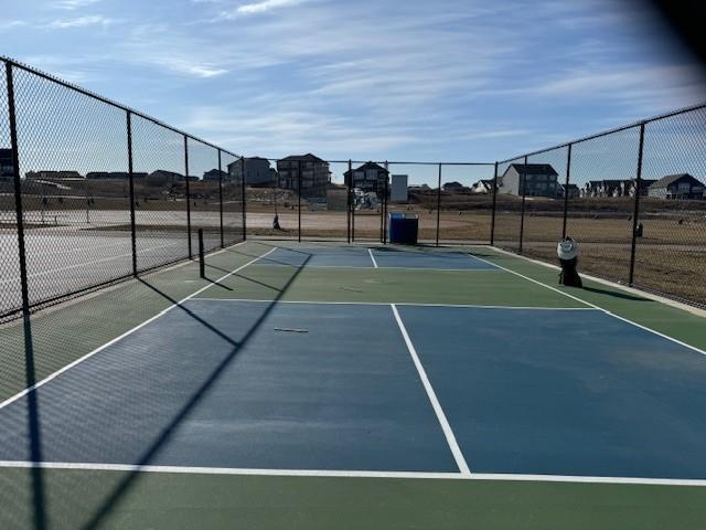 view of tennis court featuring fence