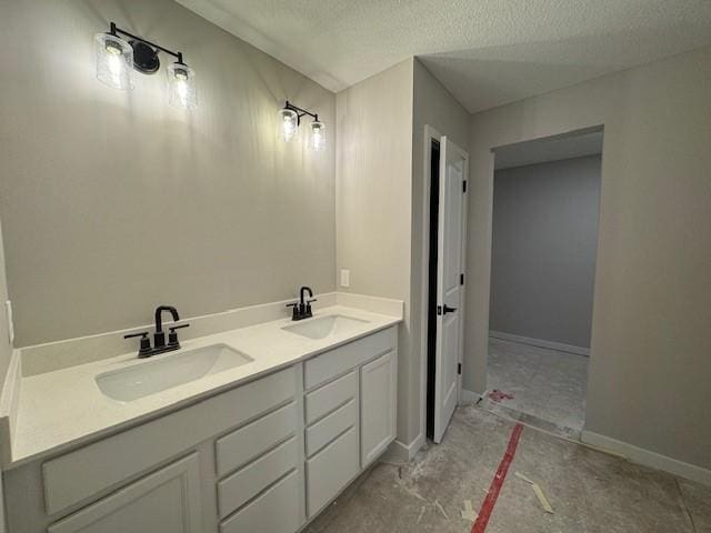 bathroom with double vanity, a sink, and a textured ceiling