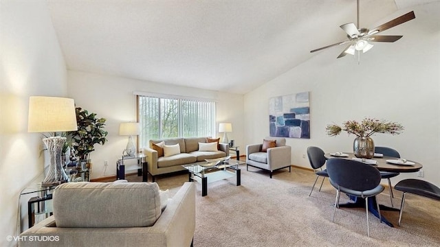 living area featuring a ceiling fan, baseboards, light carpet, and vaulted ceiling