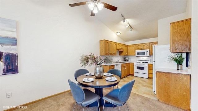 kitchen with a ceiling fan, a sink, light countertops, light carpet, and white appliances