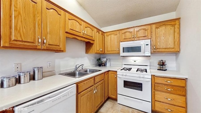 kitchen featuring lofted ceiling, white appliances, light countertops, a textured ceiling, and a sink